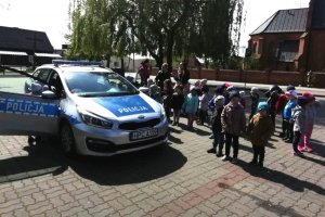 Przedszkolaki oglądają policyjny radiowóz oraz wyposażenie policjanta
