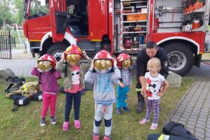 Dzieci przymierzają hełmy strażackie