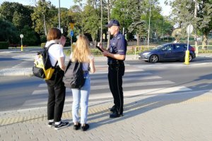 Policjant rozmawia z młodzieżą o bezpieczeństwie na drodze