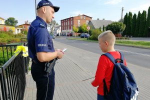 Policjant tłumaczy chłopcu zasady ruchu drogowego