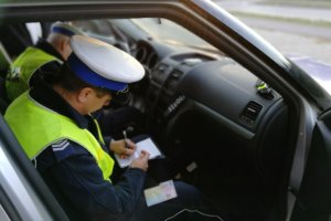 Policjanci dokumentują czynności w radiowozie