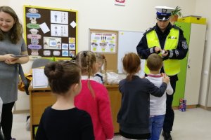 Policjantka obdarowuje przedszkolaków odblaskami