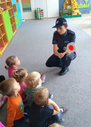 Policjantka prezentuje przedszkolakom sprzęt wykorzystywany w służbie