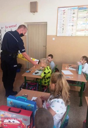Policjant pokazuje chłopcu magiczną tubę