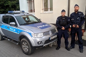 Policjanci ogniwa prewencji z komisariatu w Nowem na tle radiowozu