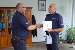 Komendant gratuluje policjantowi jubileuszu, składa na jego ręce list gratulacyjny