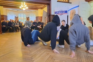 Aktorzy siedzą na podłodze podczas przedstawienia