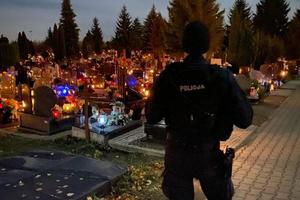 Policjant dbając o ład i porządek  publiczny patroluje teren cmentarza