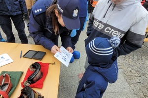 Policjantka pokazuje chłopcu odciski palców