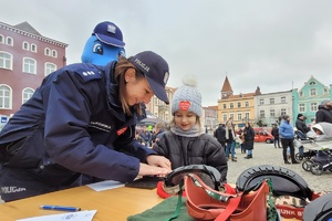Policjantka wykonuje odcisk linii papilarnych dziecka
