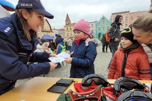 Policjantka wręcz dziewczynce kartkę z odciskami palców
